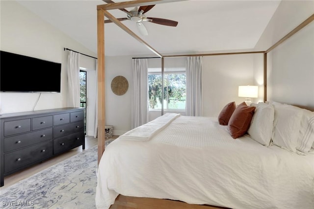 bedroom with vaulted ceiling, multiple windows, and a ceiling fan