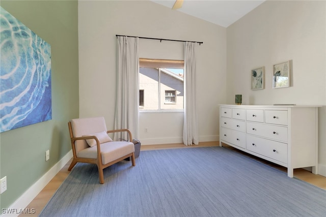 living area with lofted ceiling, light wood-type flooring, and baseboards