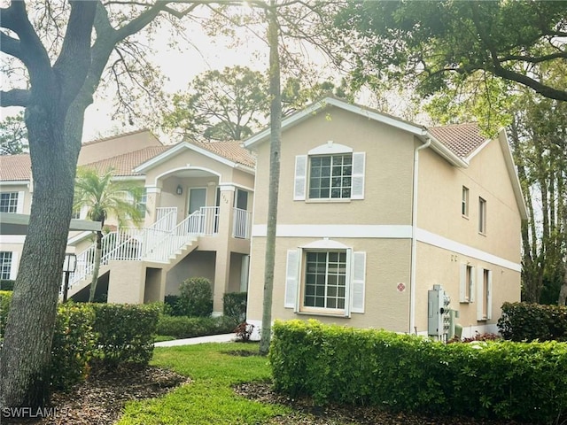 view of front of house with stairs and stucco siding