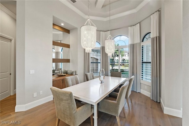 dining room with crown molding, wood finished floors, and a notable chandelier