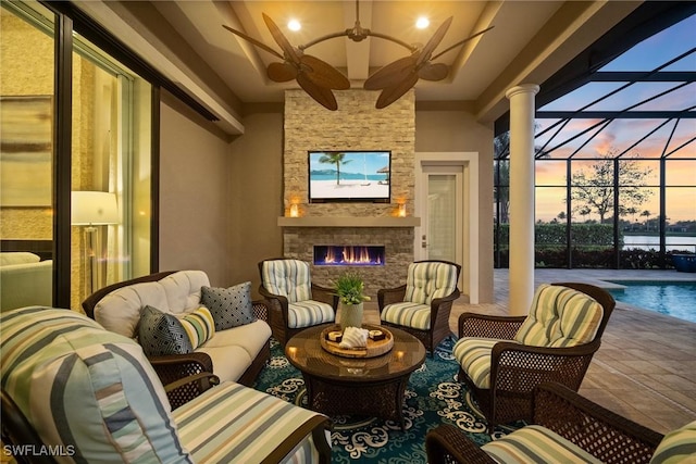 interior space featuring a lanai, an outdoor living space with a fireplace, an outdoor pool, and ceiling fan