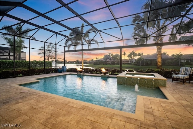 pool at dusk with a patio, a lanai, and a pool with connected hot tub