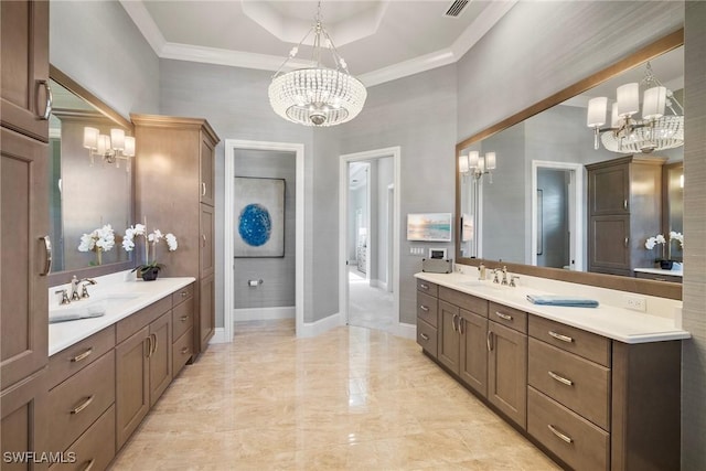 bathroom with ornamental molding, two vanities, a sink, and a notable chandelier