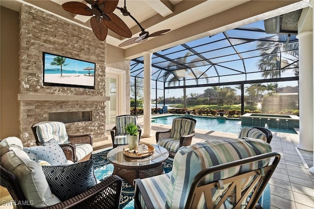 view of patio featuring a lanai, an outdoor living space with a fireplace, a pool with connected hot tub, and ceiling fan