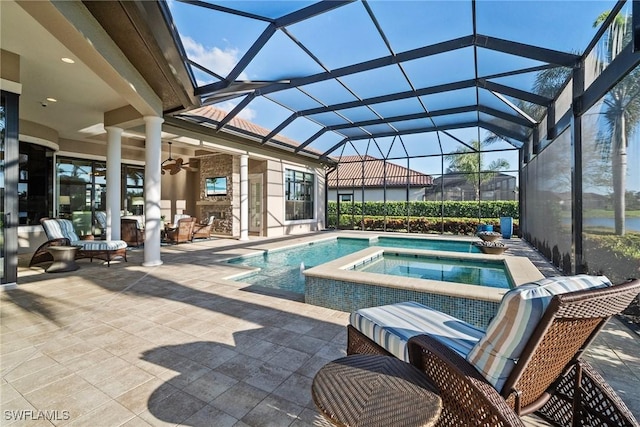 outdoor pool with a lanai, a patio area, a ceiling fan, and an in ground hot tub