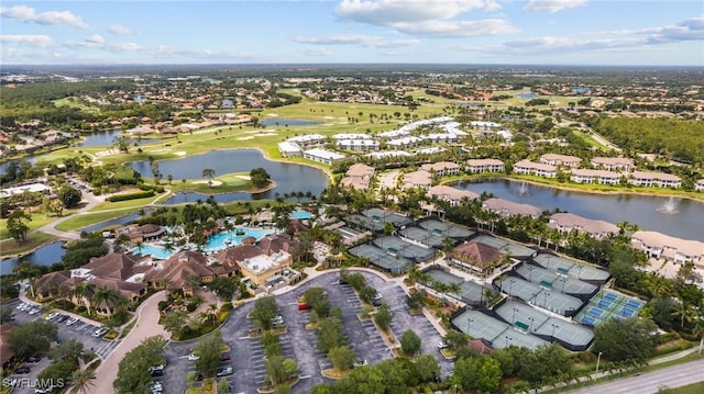 drone / aerial view featuring golf course view, a water view, and a residential view