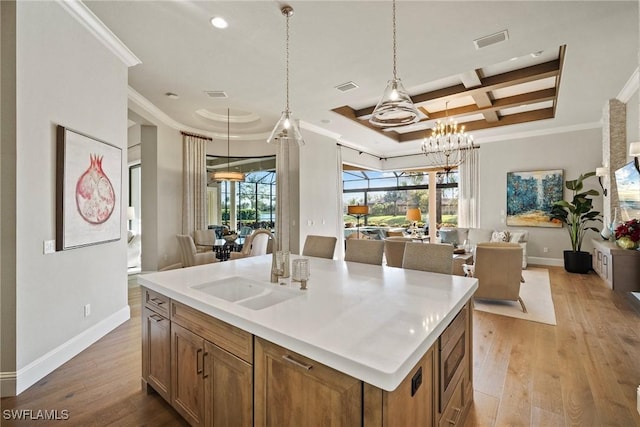kitchen with open floor plan, coffered ceiling, visible vents, and a sink