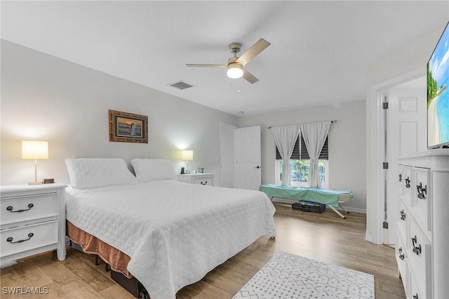 bedroom featuring a ceiling fan, baseboards, visible vents, and light wood finished floors