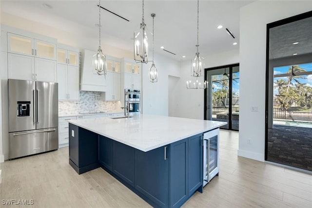 kitchen with white cabinetry, wine cooler, appliances with stainless steel finishes, decorative backsplash, and custom exhaust hood