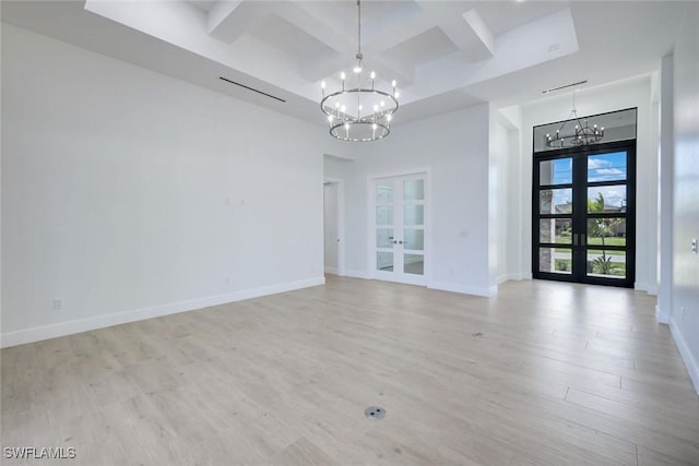 unfurnished room with light wood finished floors, baseboards, a chandelier, french doors, and coffered ceiling