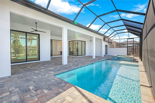 view of pool featuring glass enclosure, a patio, a pool with connected hot tub, and a ceiling fan