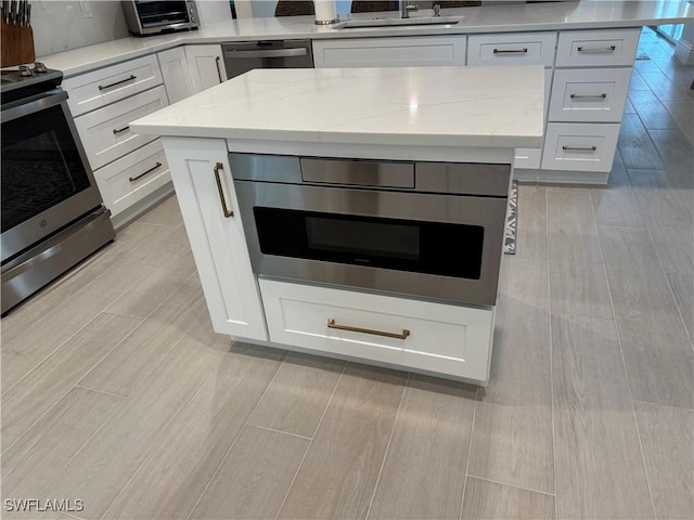 kitchen with electric range, a sink, white cabinetry, light stone countertops, and dishwasher