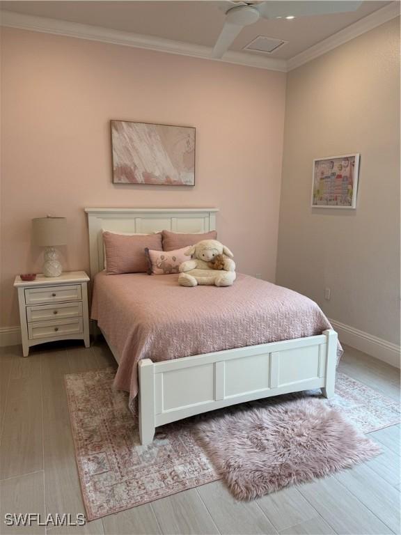 bedroom featuring crown molding, baseboards, and wood finished floors