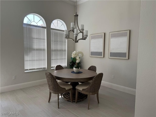 dining room featuring light wood-type flooring, an inviting chandelier, and baseboards