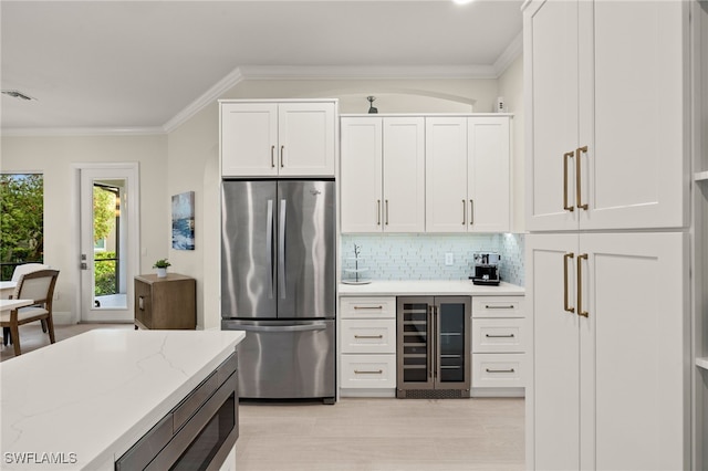 kitchen with visible vents, white cabinetry, wine cooler, appliances with stainless steel finishes, and crown molding