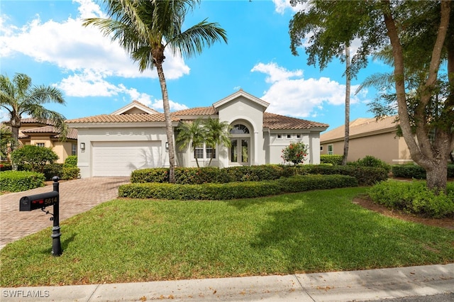 mediterranean / spanish house with stucco siding, an attached garage, decorative driveway, and a front yard