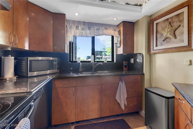 kitchen with tile patterned flooring, electric range, a sink, backsplash, and stainless steel microwave