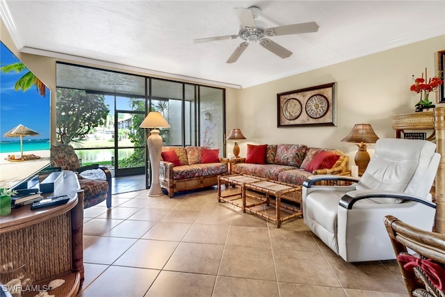 living room featuring a ceiling fan, expansive windows, light tile patterned flooring, and crown molding