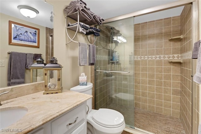 full bath featuring a stall shower, vanity, and toilet