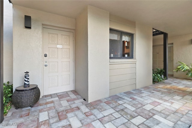 property entrance with stucco siding