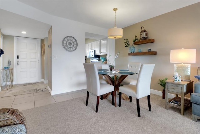 dining room with light tile patterned floors, recessed lighting, baseboards, and light colored carpet