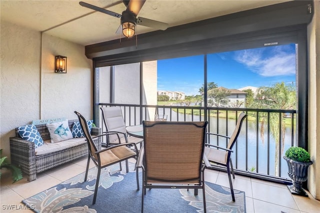 sunroom / solarium with a water view and ceiling fan