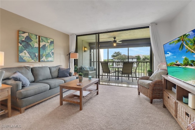 living room featuring a wall of windows, carpet flooring, and a ceiling fan