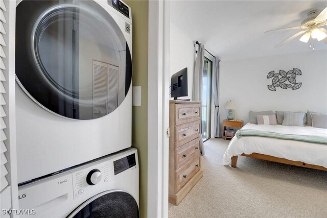 bedroom featuring stacked washer and dryer, light carpet, and ceiling fan