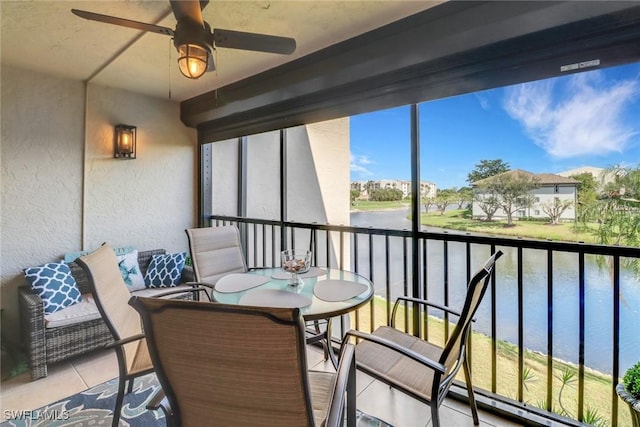 balcony featuring a water view and a ceiling fan