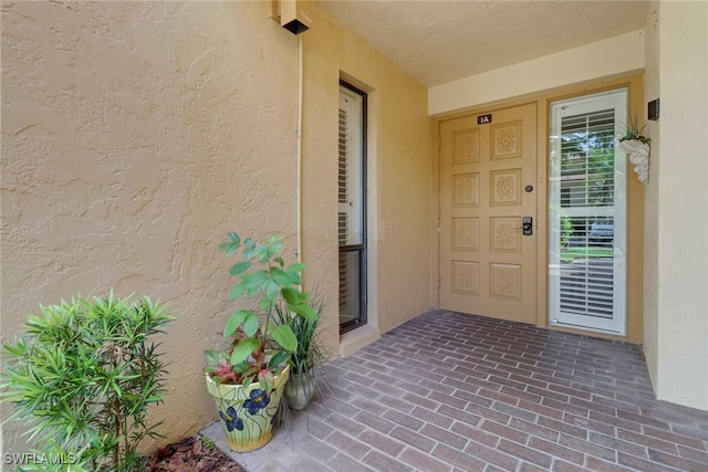 entrance to property featuring stucco siding