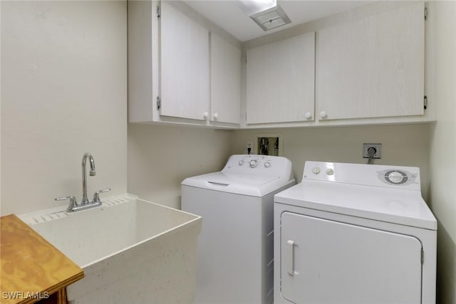 clothes washing area featuring cabinet space, a sink, and washing machine and clothes dryer