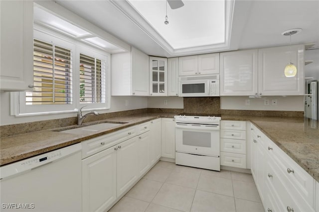 kitchen featuring white appliances, white cabinets, a sink, and light tile patterned flooring