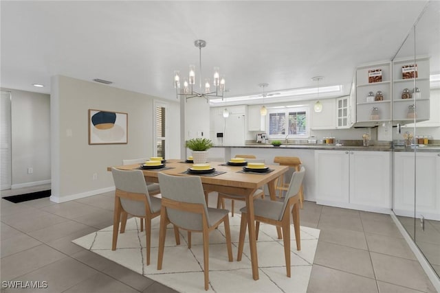 dining room with light tile patterned flooring, a notable chandelier, visible vents, and baseboards