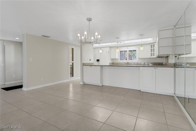 kitchen with light tile patterned floors, dark countertops, glass insert cabinets, white cabinetry, and baseboards