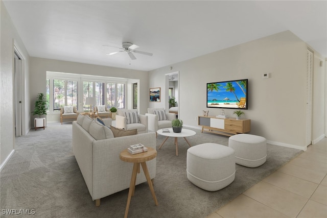 tiled living room with ceiling fan and baseboards