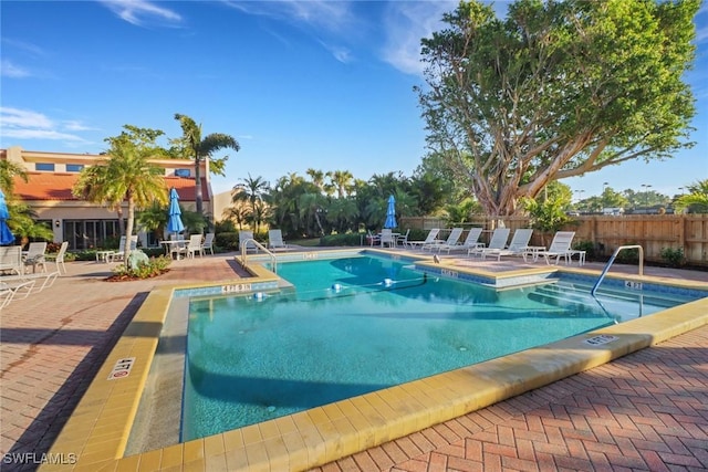 community pool featuring fence and a patio