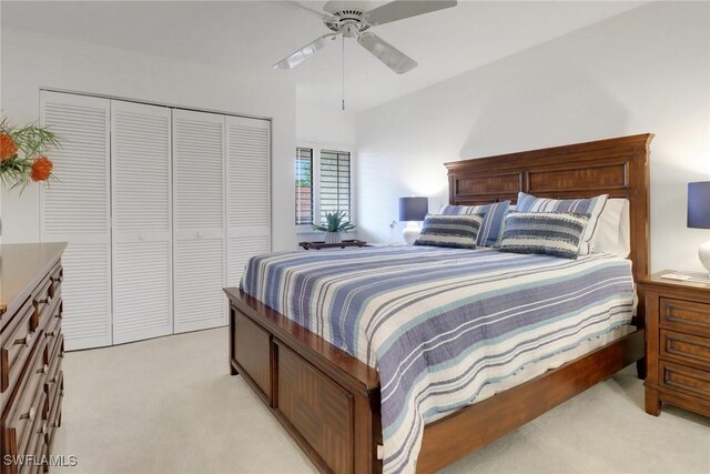 bedroom featuring light carpet, a ceiling fan, and a closet