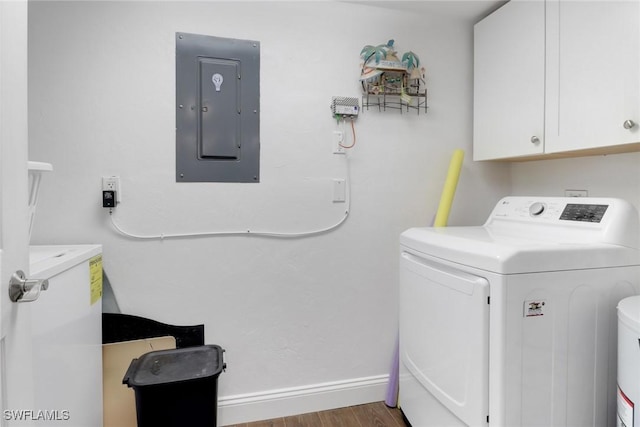 laundry room featuring cabinet space, electric panel, baseboards, washer and clothes dryer, and wood finished floors