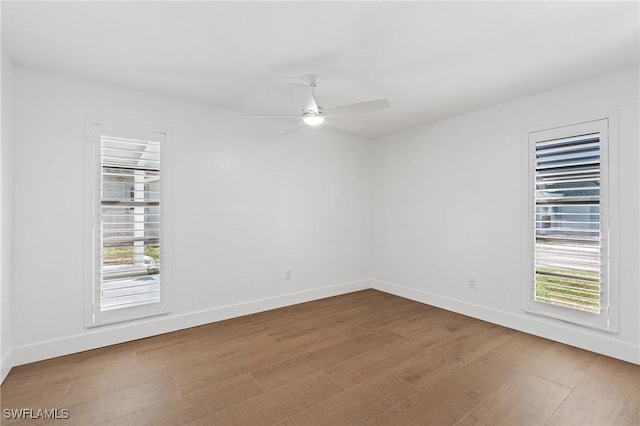 unfurnished room featuring ceiling fan, baseboards, and wood finished floors