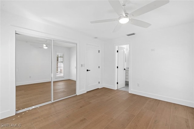 unfurnished bedroom featuring baseboards, visible vents, ceiling fan, and wood finished floors