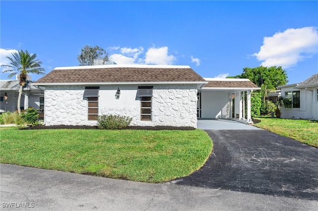 view of front of house with aphalt driveway, a front yard, stone siding, and roof with shingles