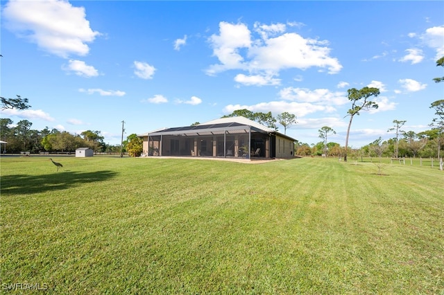 view of yard featuring glass enclosure, a storage unit, and an outdoor structure