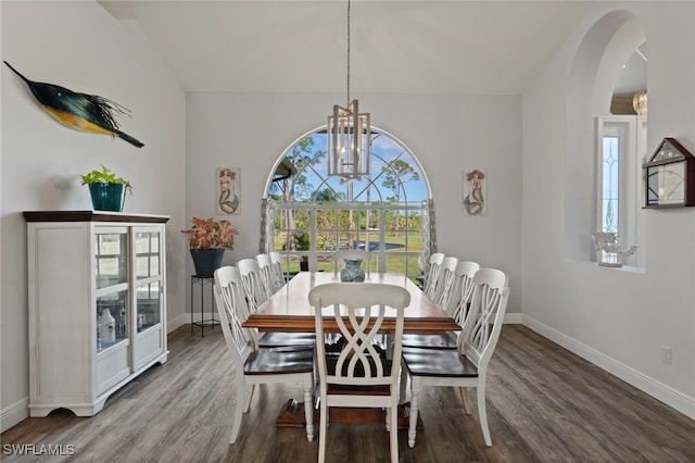 dining room featuring a chandelier, wood finished floors, and baseboards