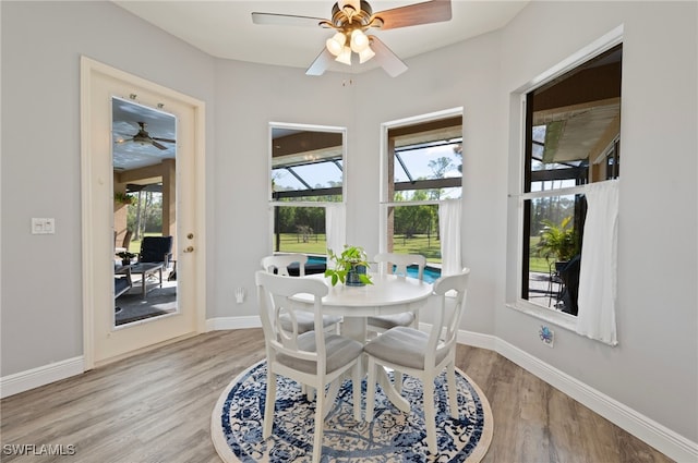 dining area with baseboards, light wood finished floors, and a healthy amount of sunlight