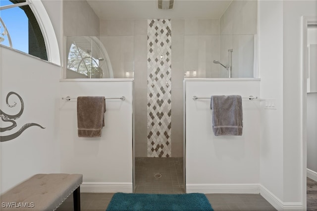 bathroom with a walk in shower and baseboards