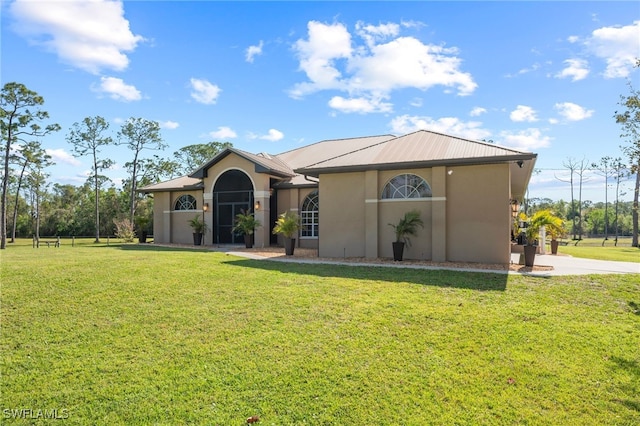 single story home featuring metal roof, a front lawn, and stucco siding