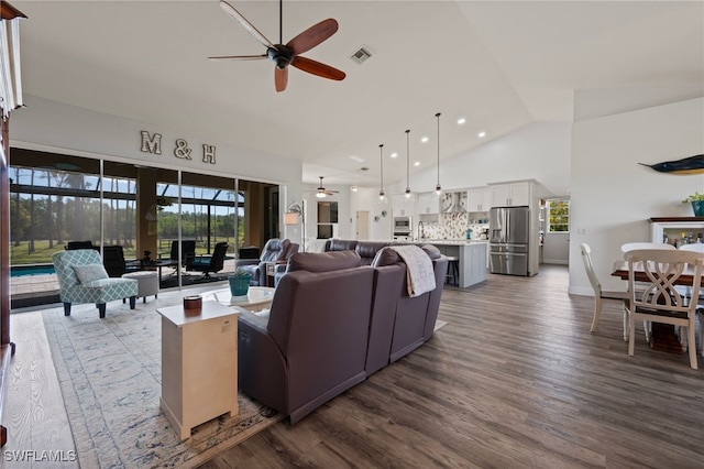 living area with high vaulted ceiling, visible vents, plenty of natural light, and dark wood-type flooring