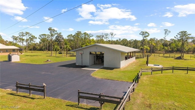 exterior space featuring fence, aphalt driveway, and a lawn