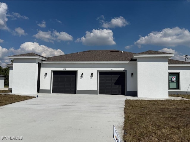 view of front of property with concrete driveway, an attached garage, and stucco siding