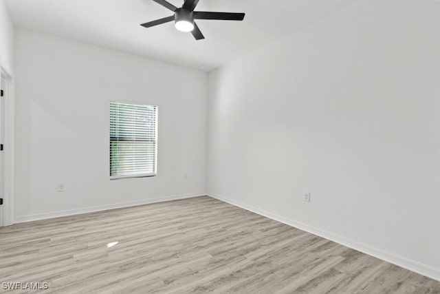 empty room with light wood finished floors, baseboards, and a ceiling fan